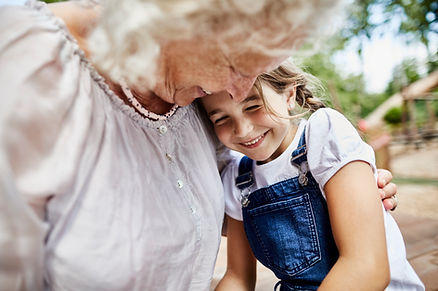 A grandmother and granddaughter embracing.